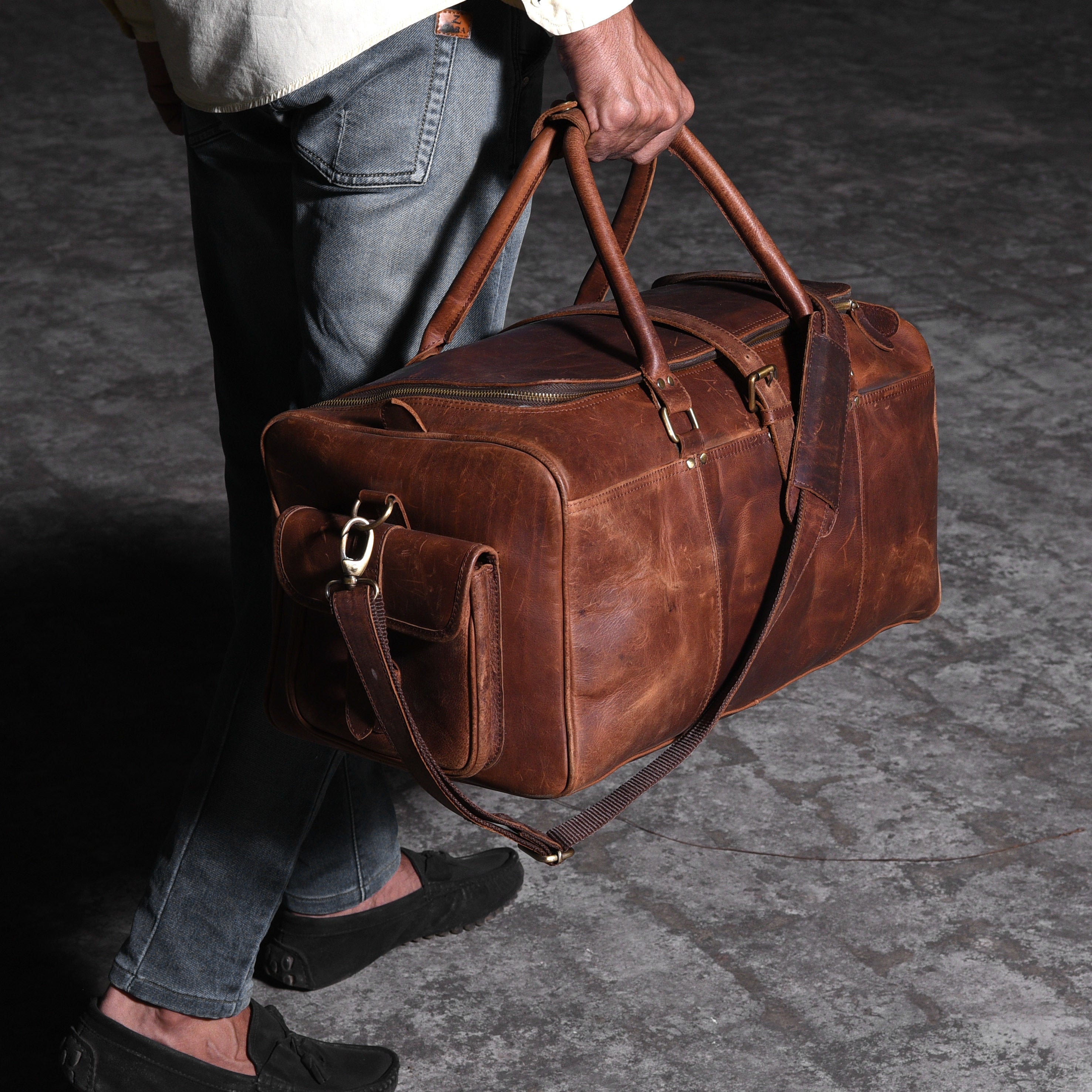 Photo of a man walking with a leather travel bag